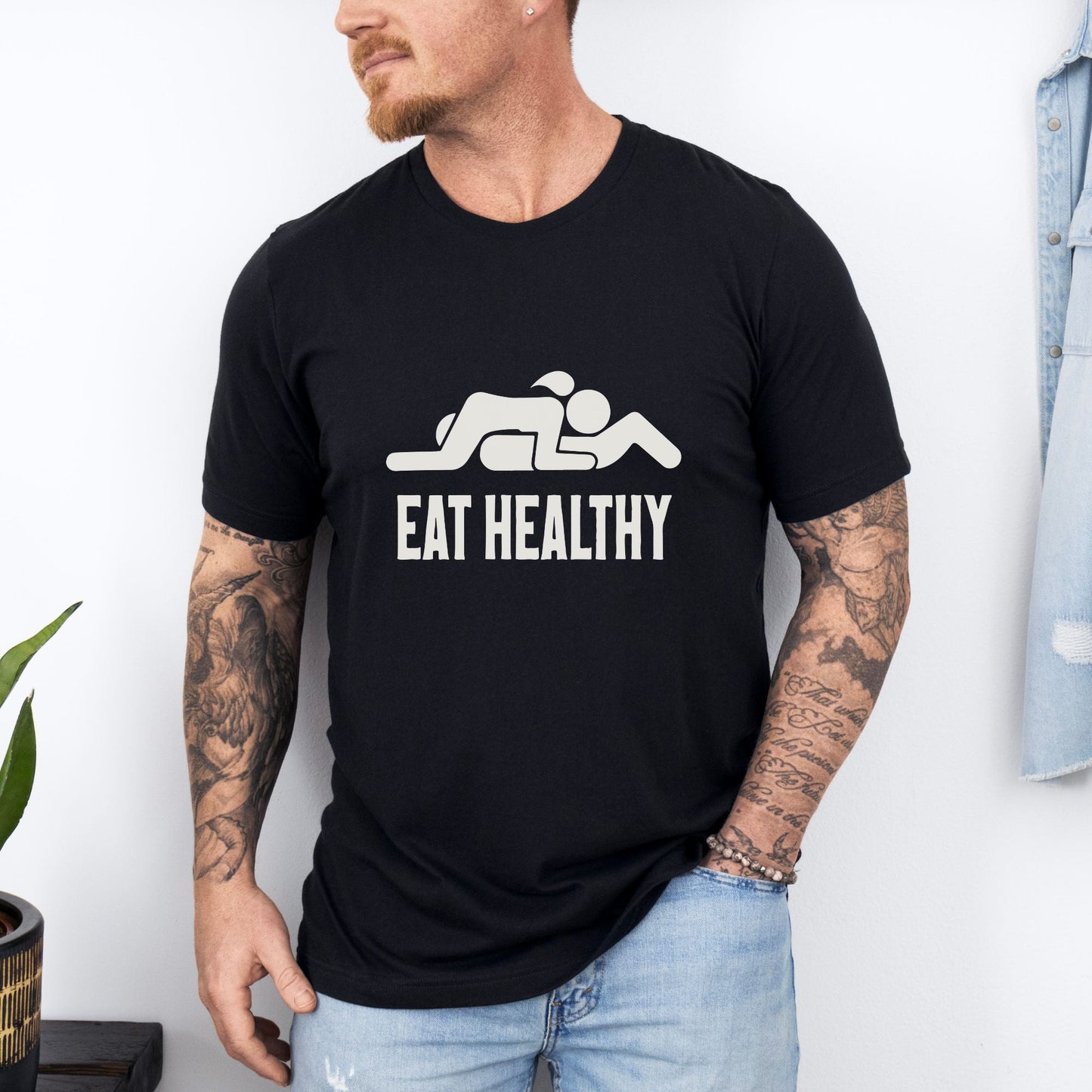 a man wearing a black t - shirt that says eat healthy