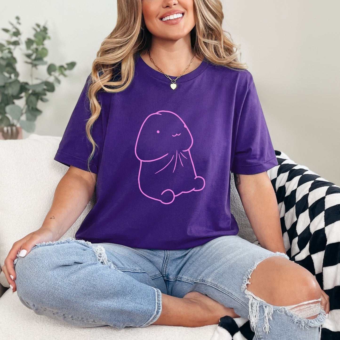 a woman sitting on a couch wearing a purple shirt