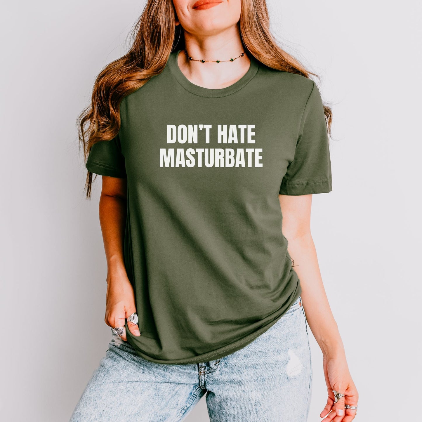 a woman wearing a green don't hate masturdale t - shirt