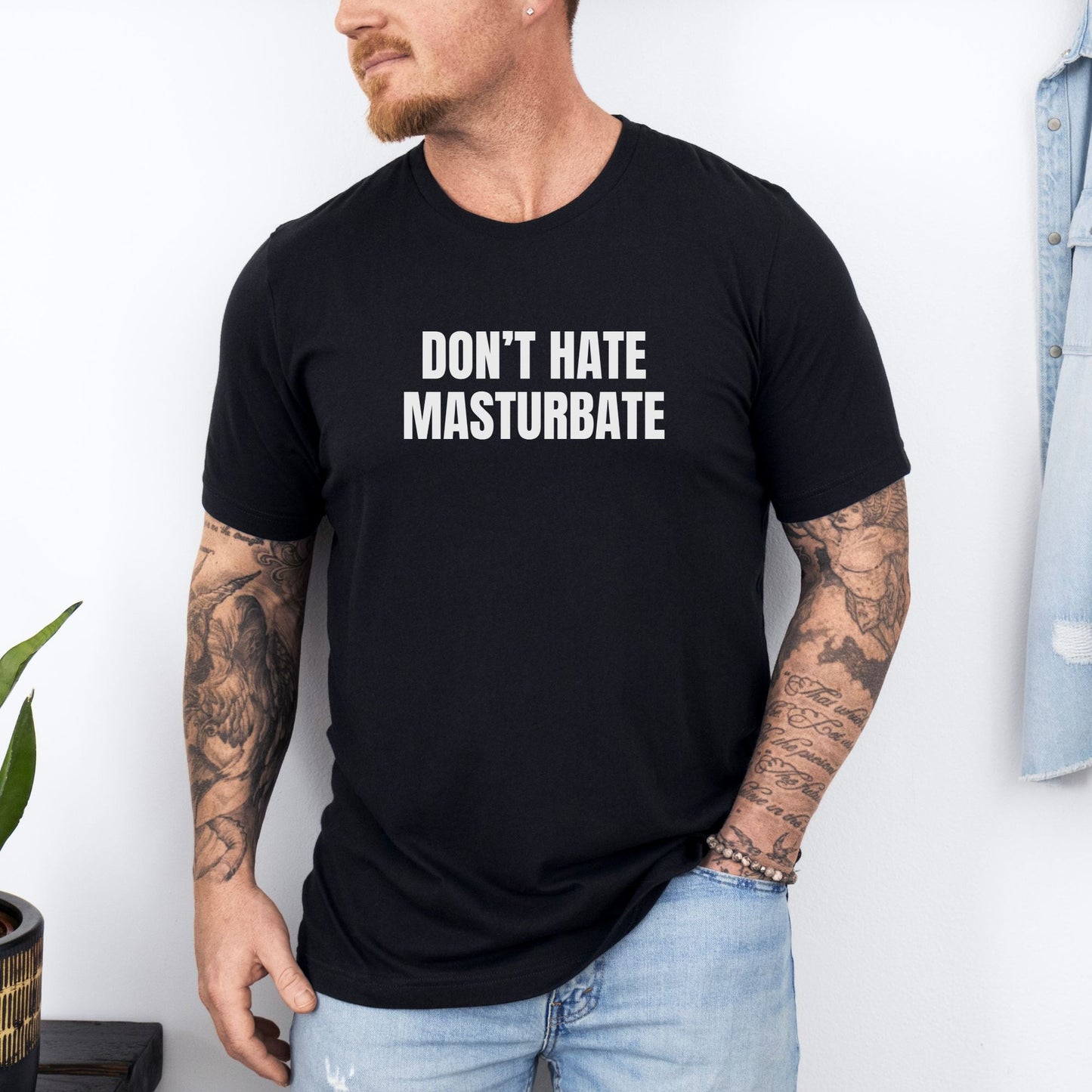 a man wearing a black t - shirt with the words don't hate mas