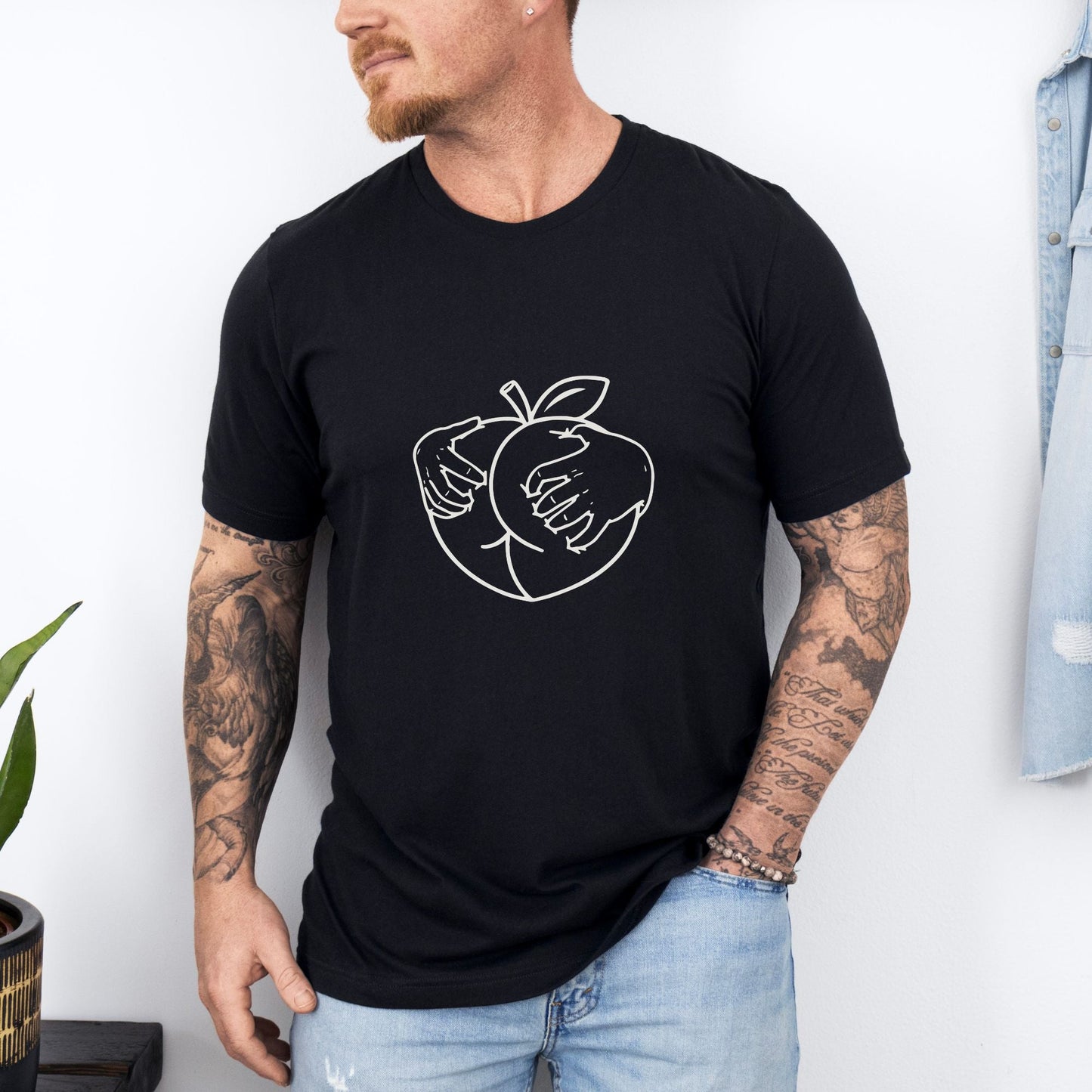 a man wearing a black shirt with an apple on it