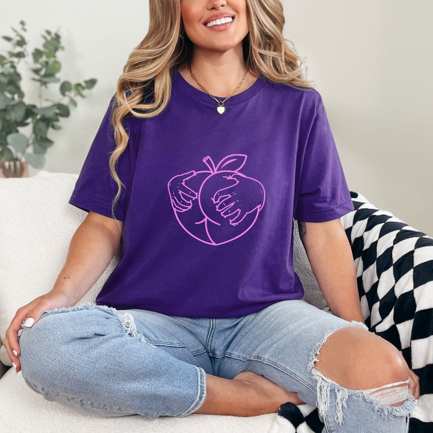 a woman sitting on a couch wearing a purple shirt