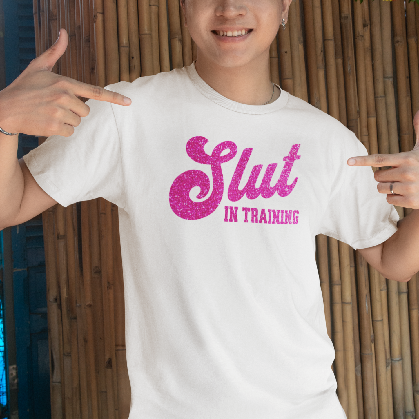 a man wearing a white shirt with pink glitter on it