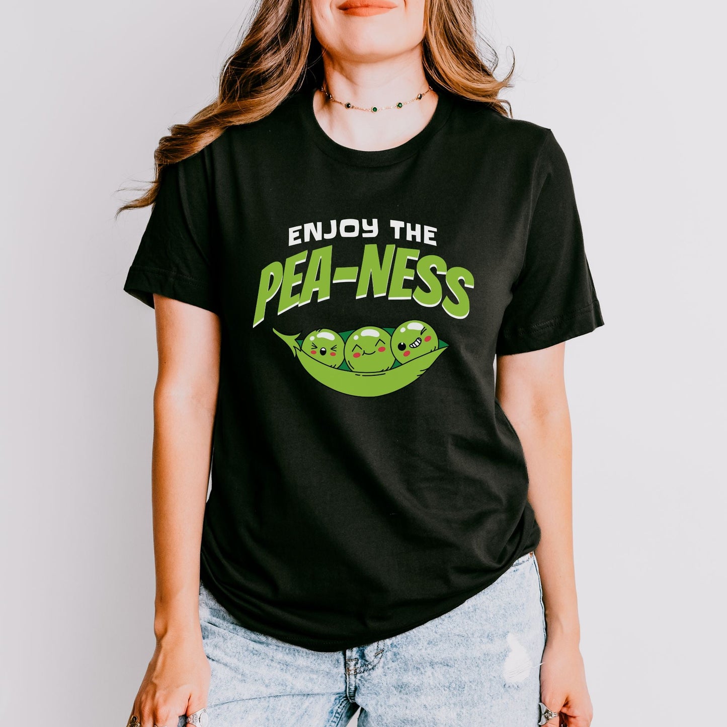 a woman wearing a black t - shirt that says enjoy the pea - nesss