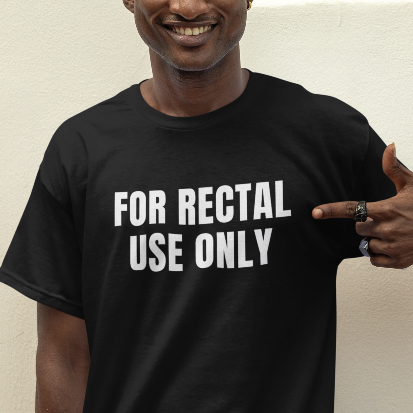 a man pointing at the camera while wearing a t - shirt