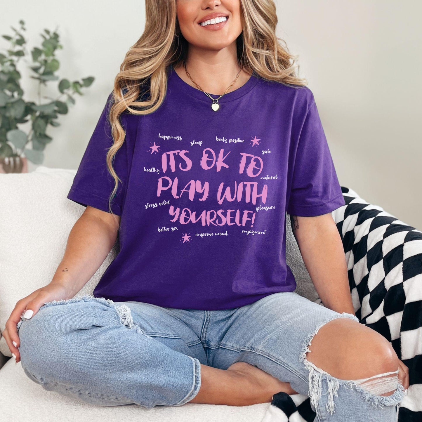 a woman sitting on a couch wearing a purple shirt