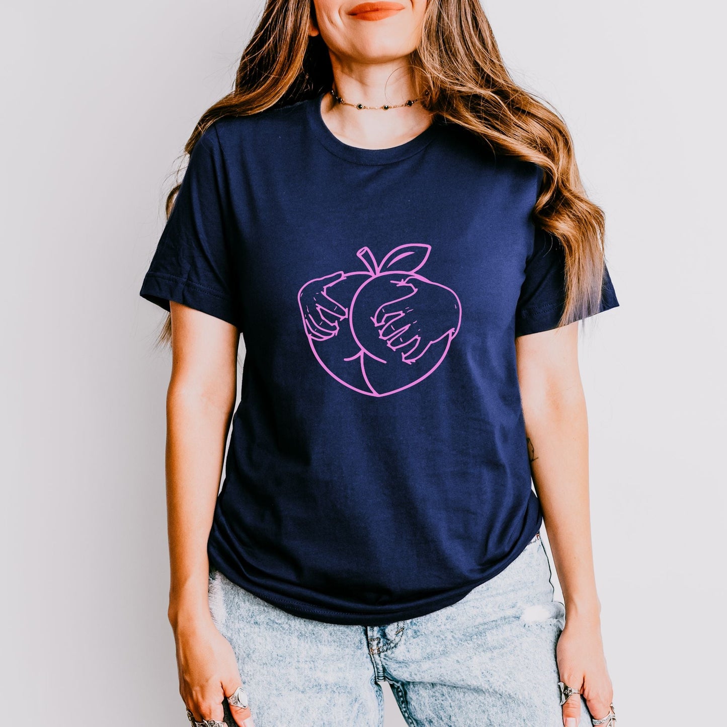 a woman wearing a t - shirt with an apple on it