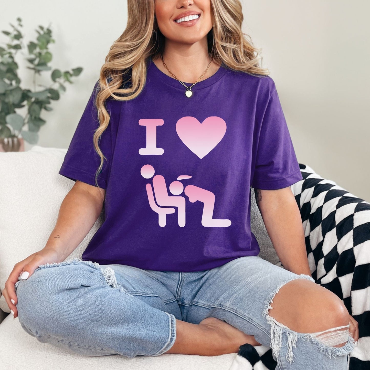 a woman sitting on a couch wearing a purple shirt