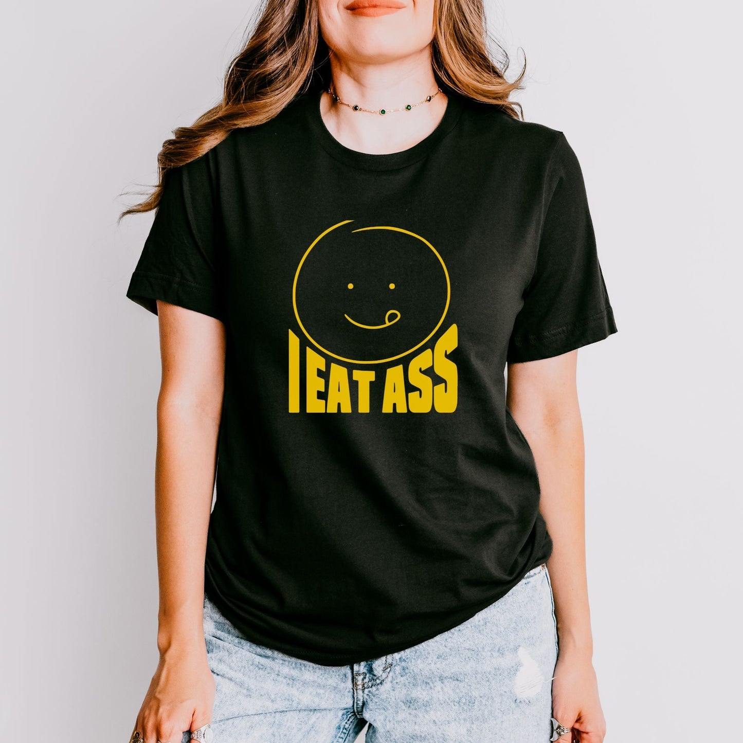 a woman wearing a black t - shirt with the words eat ass printed on it