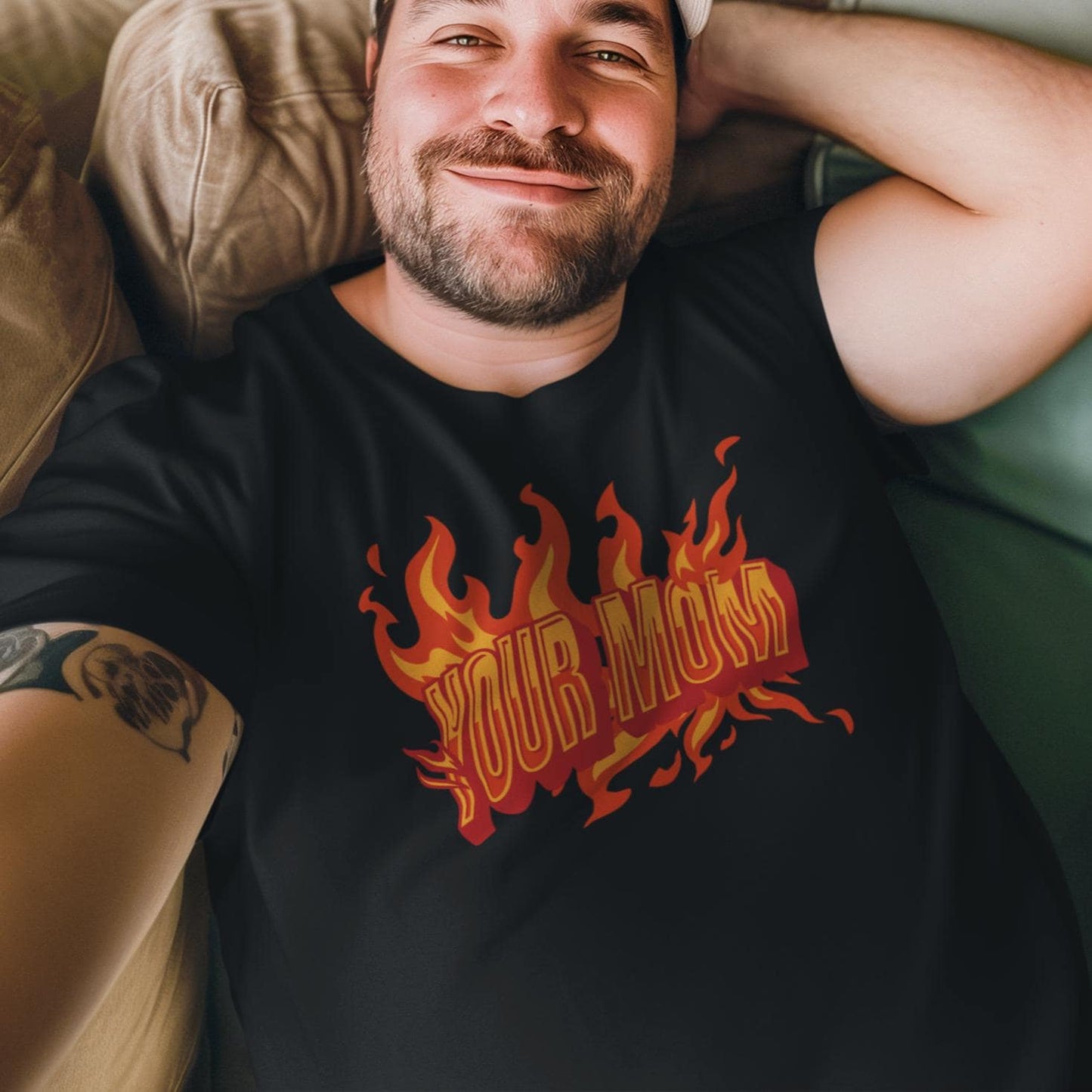 a man laying on a couch wearing a black shirt with flames on it