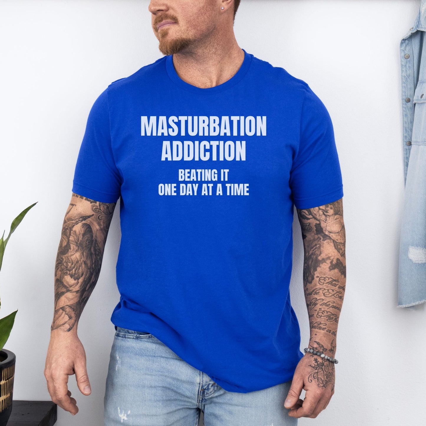 a man wearing a blue tshirt with a tattoo on his arm