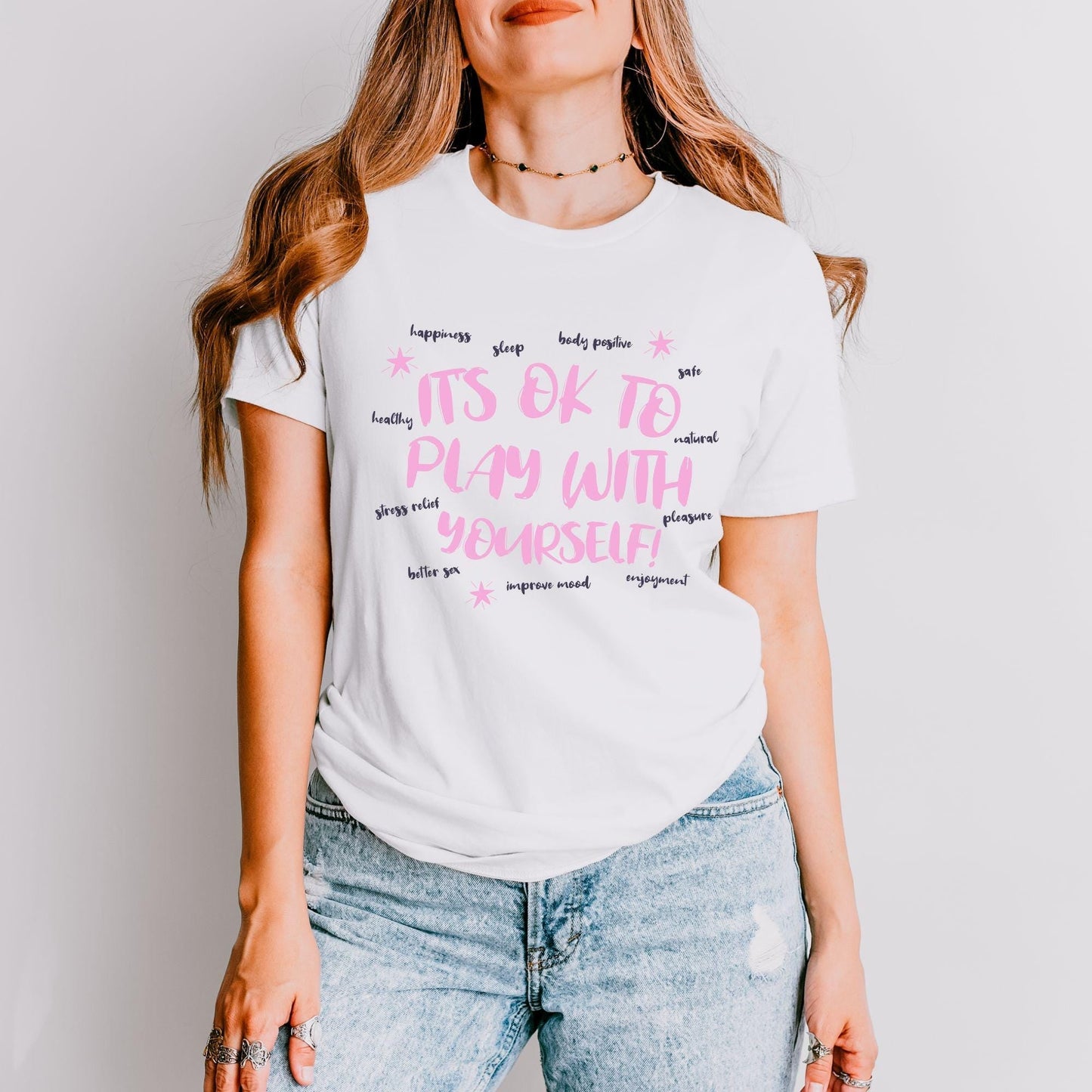 a woman wearing a white tshirt with pink writing on it