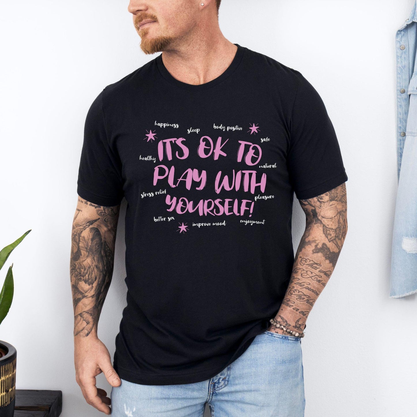 a man wearing a black tshirt with pink writing on it