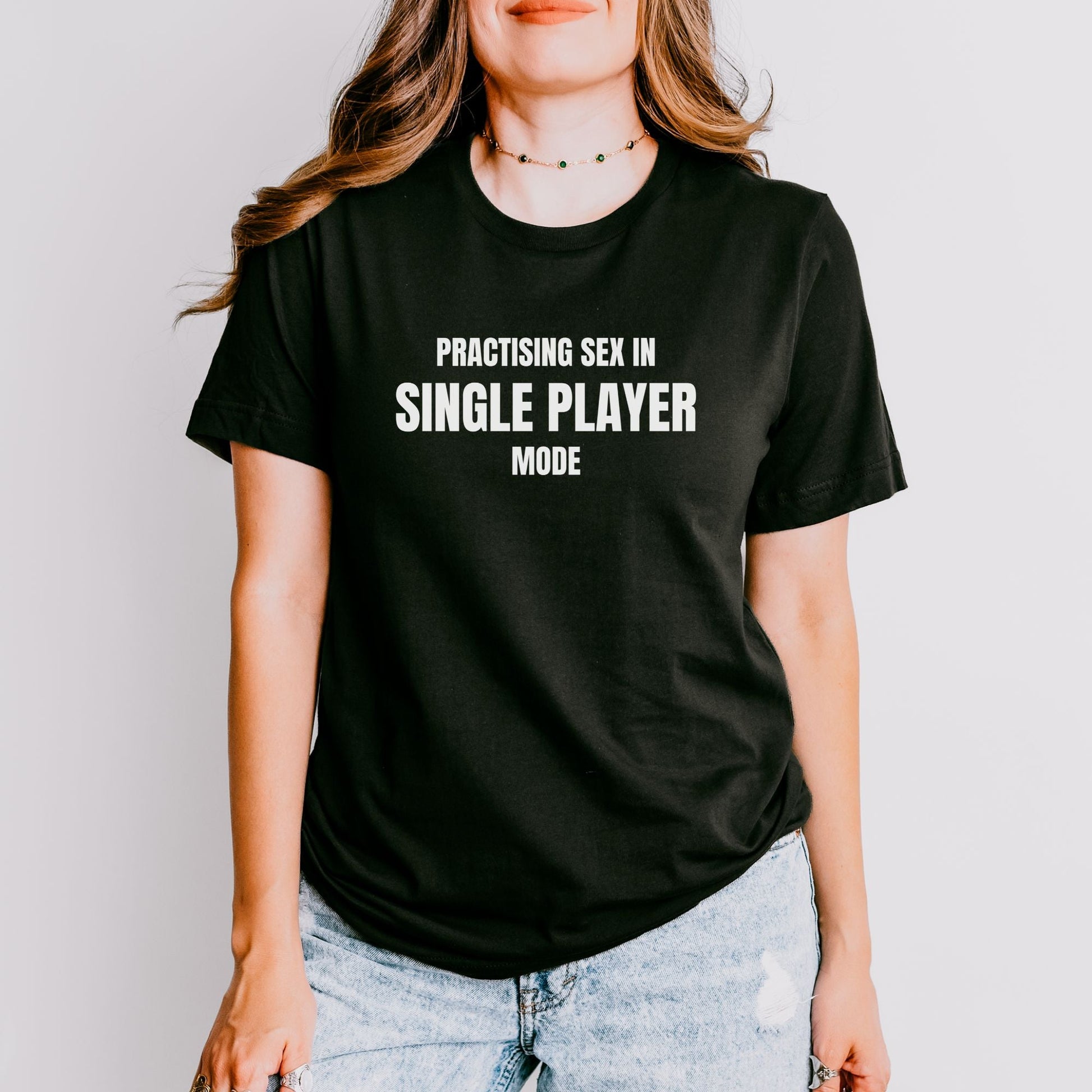 a woman wearing a black shirt that says practicing sex in single player mode