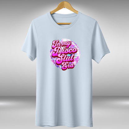 A light blue t-shirt with a graphic design featuring a disco ball and the text "In my disco slut era" printed on it.