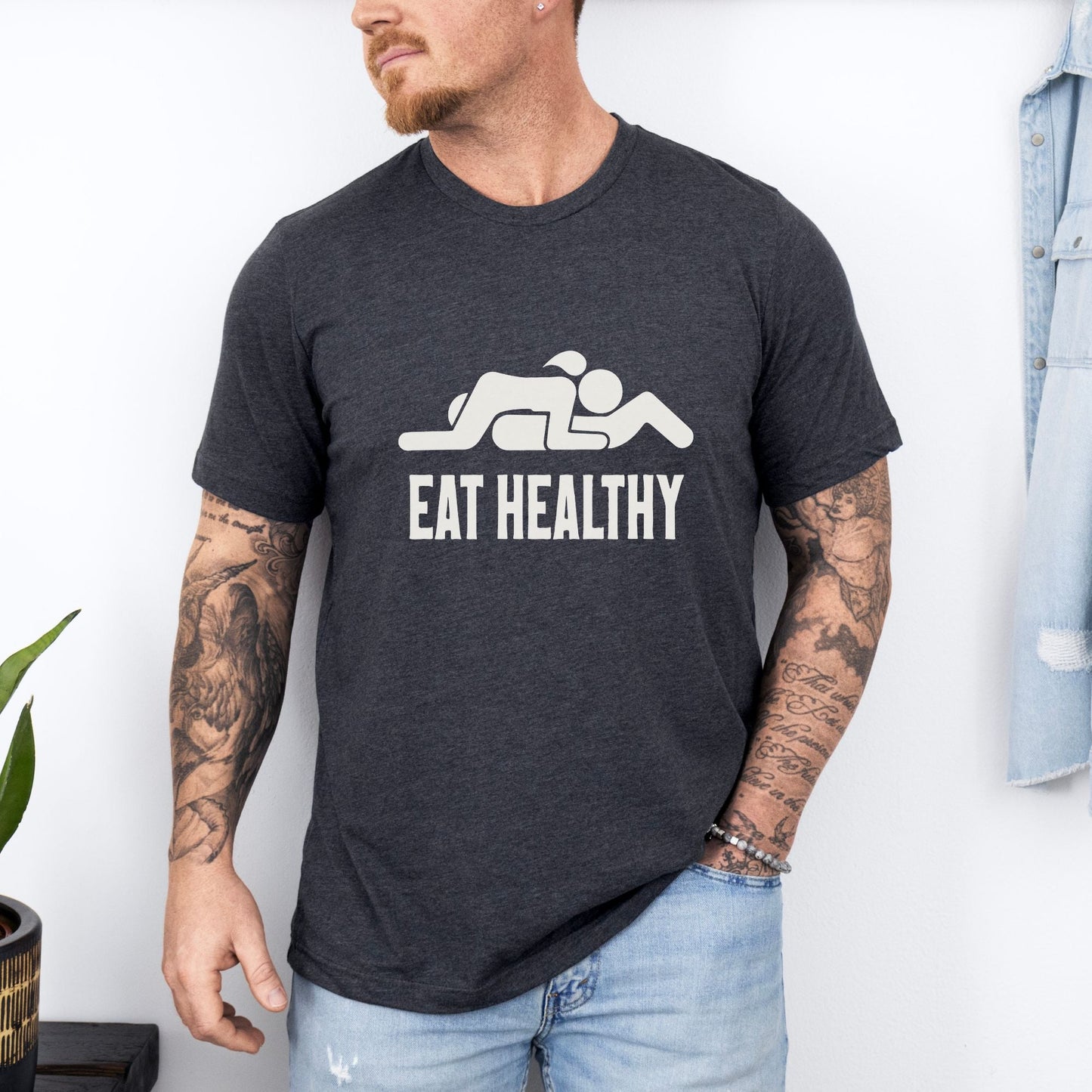 a man wearing a black t - shirt that says eat healthy