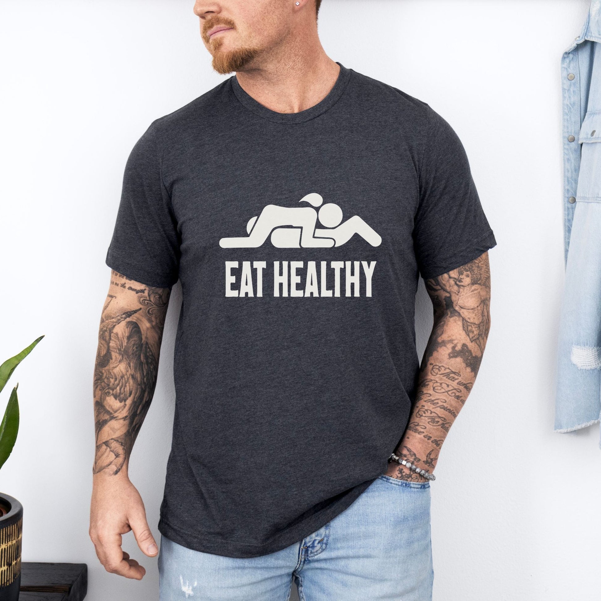 a man wearing a black t - shirt that says eat healthy