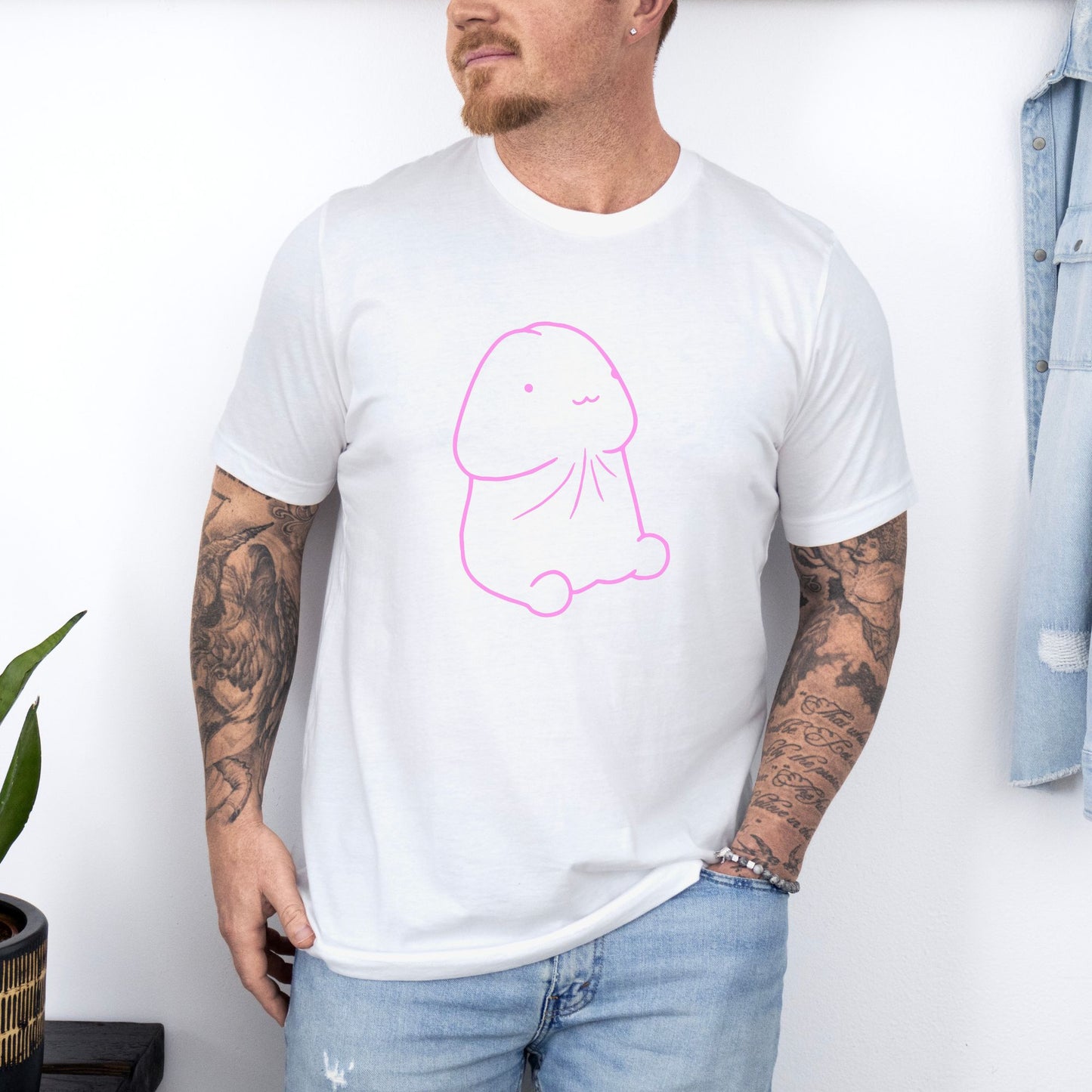 a man wearing a white t - shirt with a pink drawing of a dog