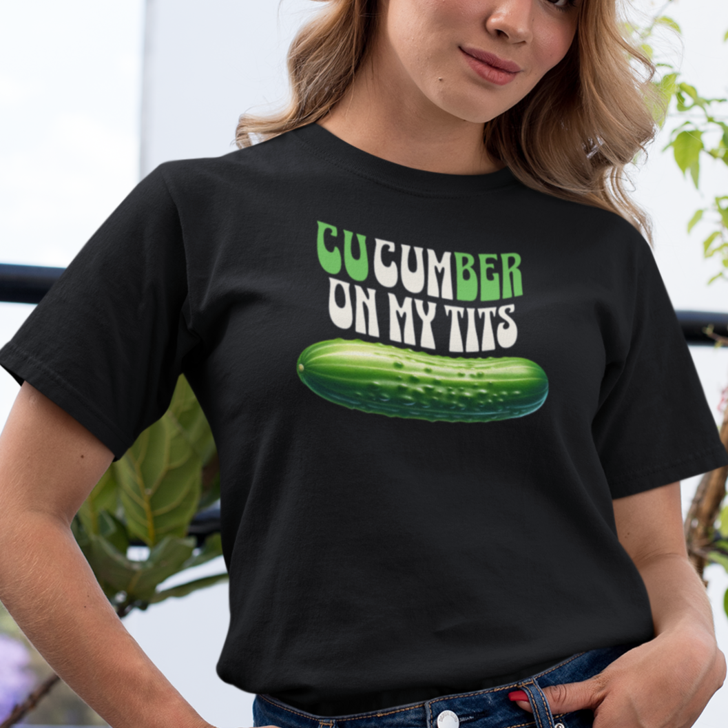 a woman wearing a black t - shirt with a cucumber on my tits