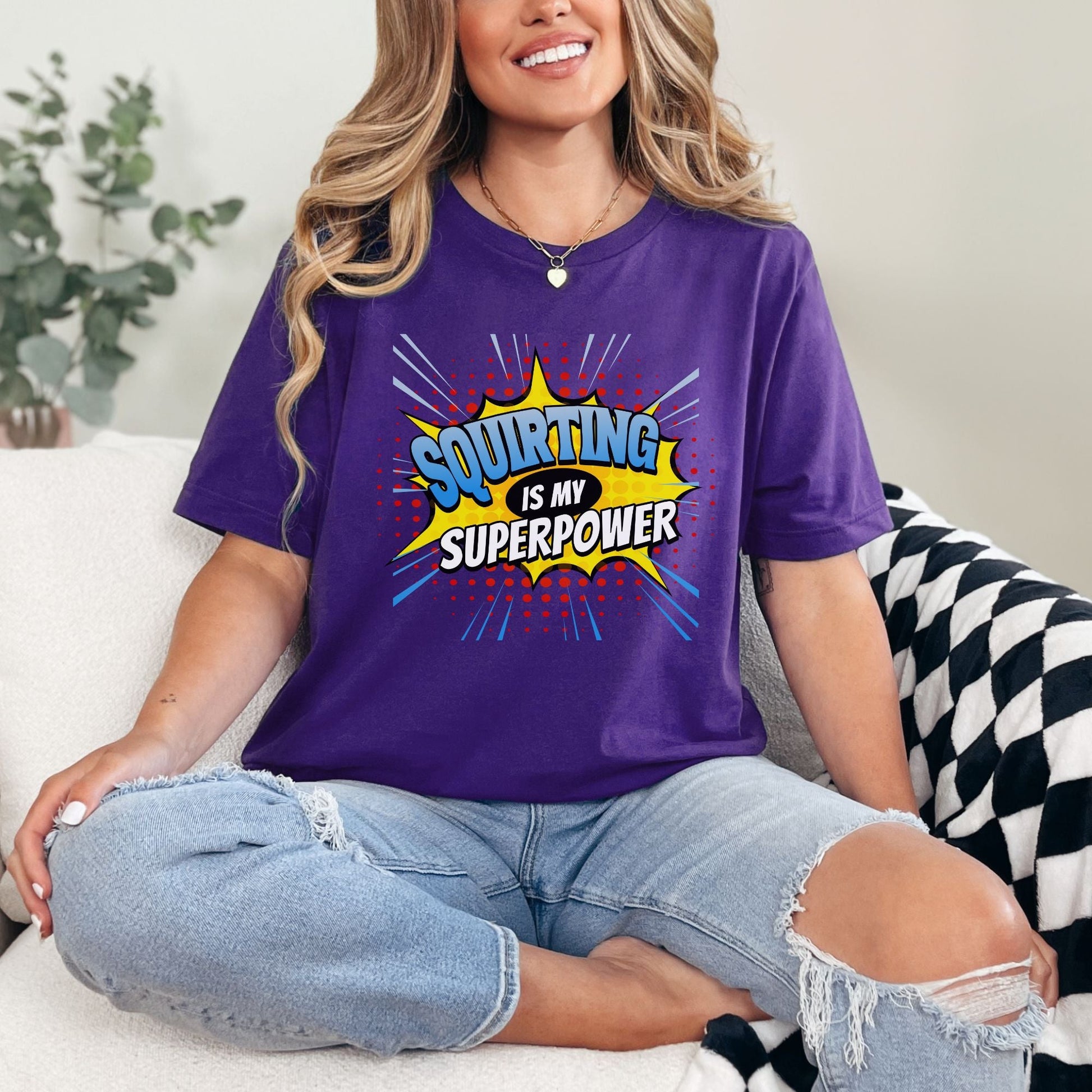 a woman sitting on a couch wearing a purple shirt