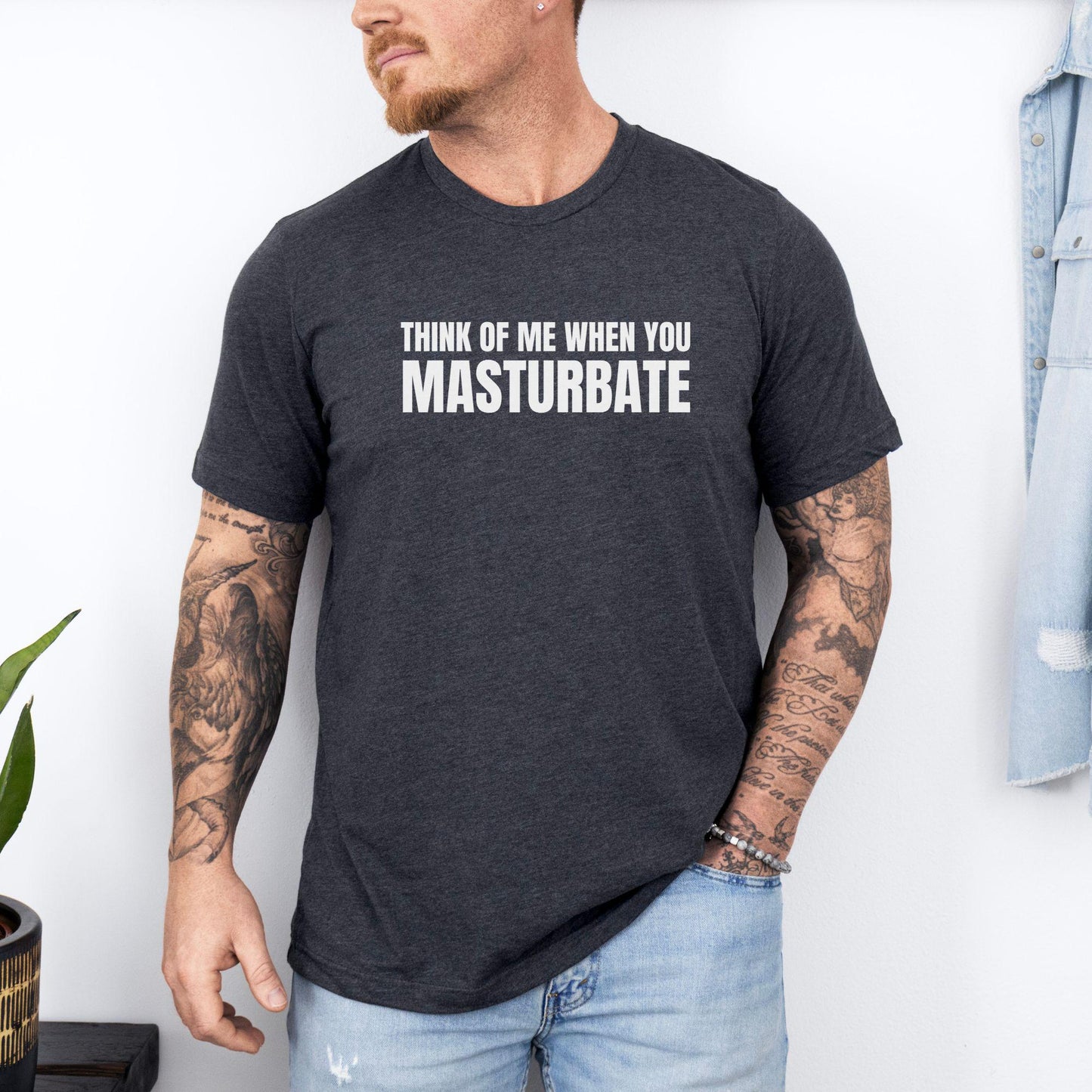 a man wearing a black t - shirt that says think of me when you mast