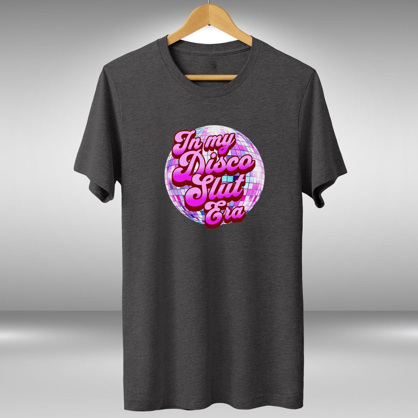 A gray t-shirt with a graphic design featuring a disco ball and the text "In my disco club era" in a stylized font.