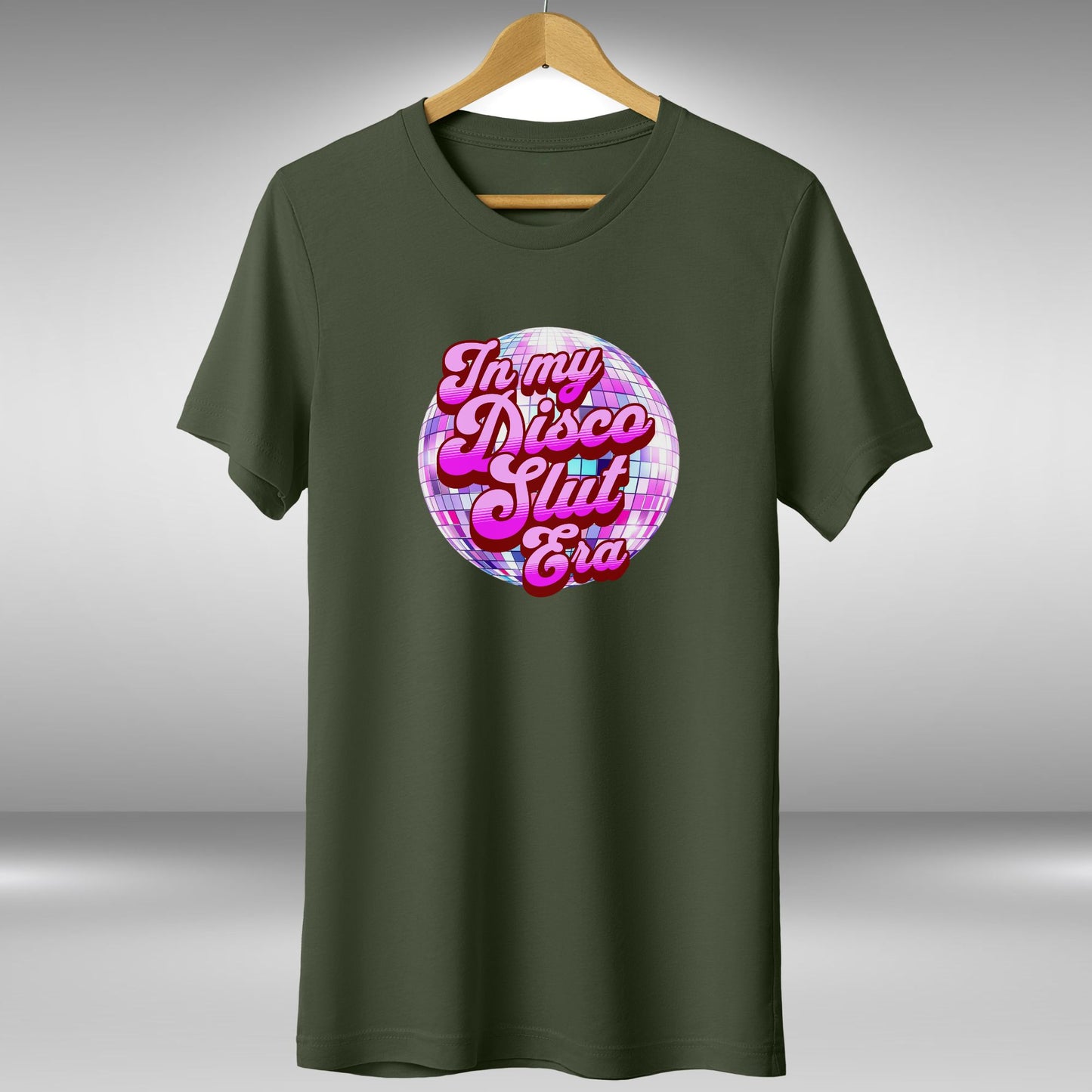 A green t-shirt with a graphic design featuring a disco ball and the text "In my disco slut era" printed on it.