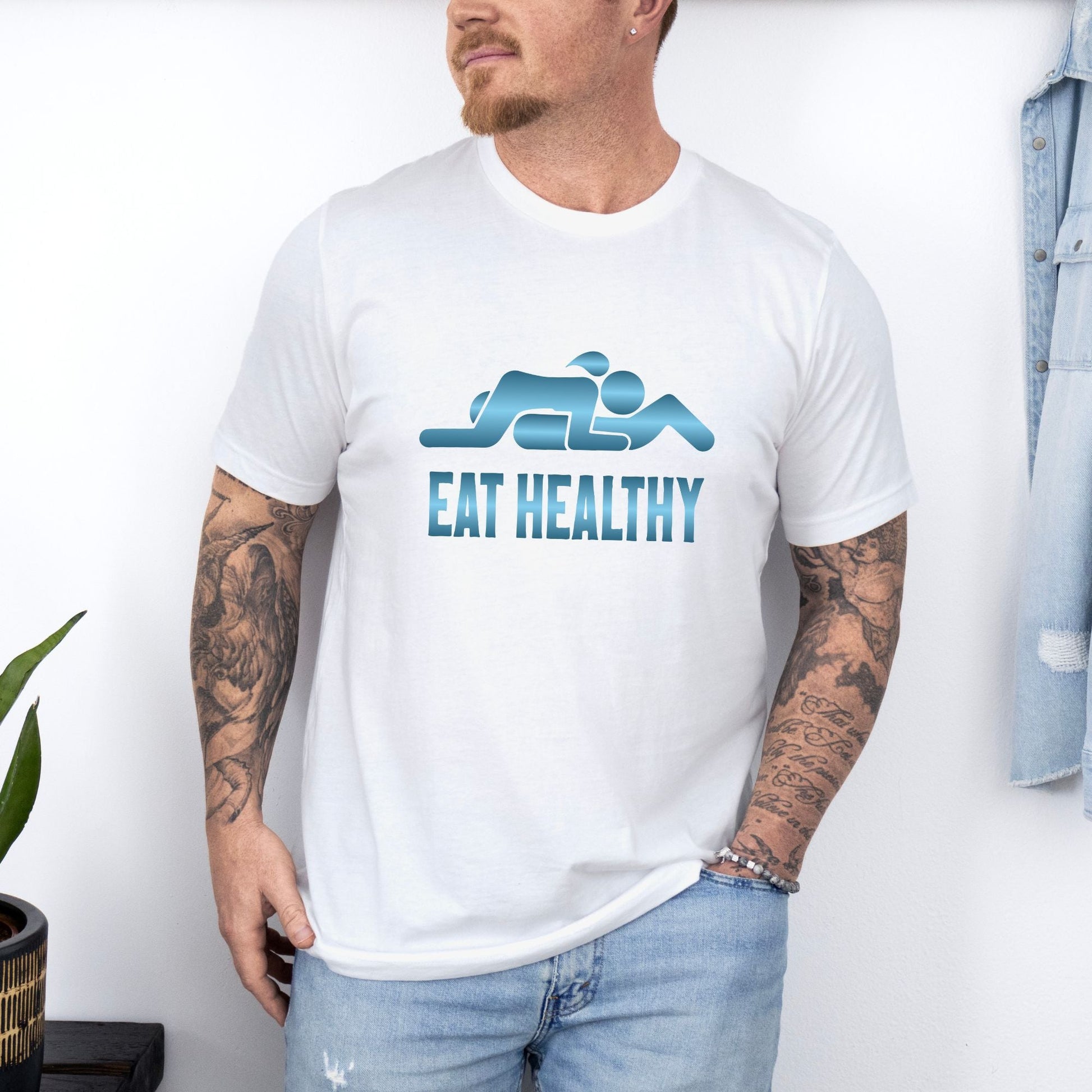 a man wearing a white t - shirt with the words eat healthy on it